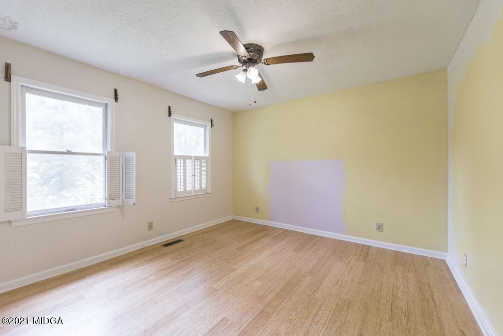 225 Beacon Hill Road Macon, GA 31210 - Photo 20 of 29 an empty room with wooden floor fan and windows