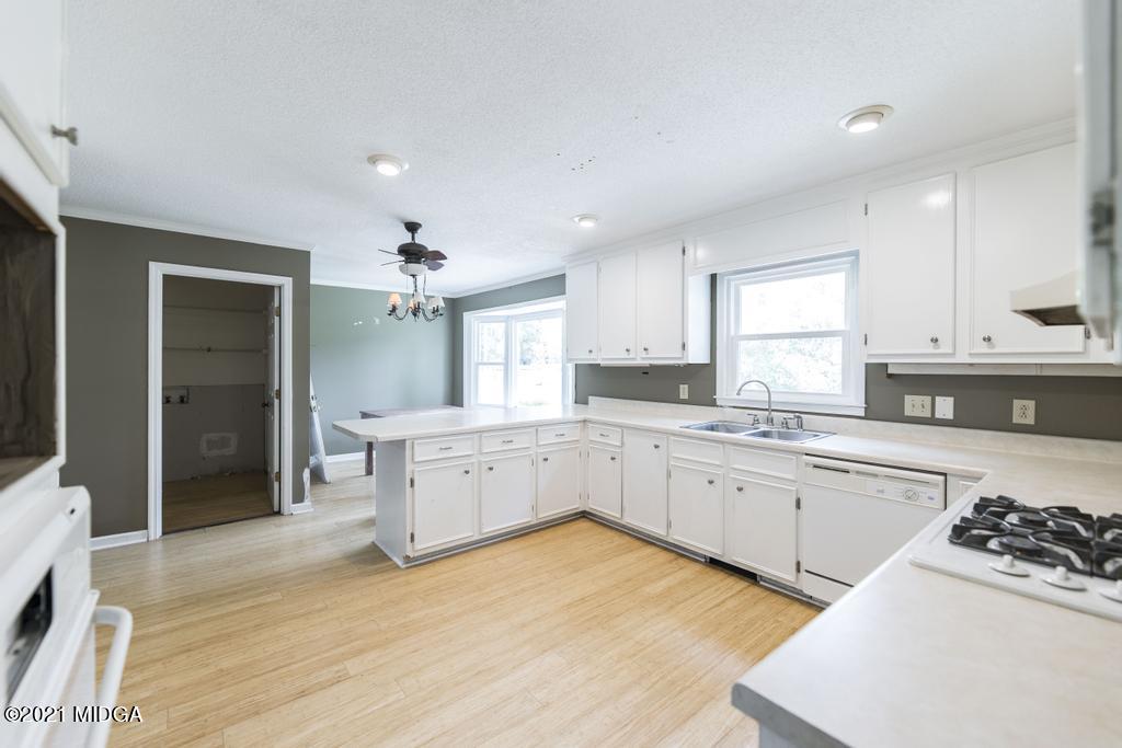 225 Beacon Hill Road Macon, GA 31210 - Photo 8 of 29 a large kitchen with kitchen island a sink stainless steel appliances and cabinets