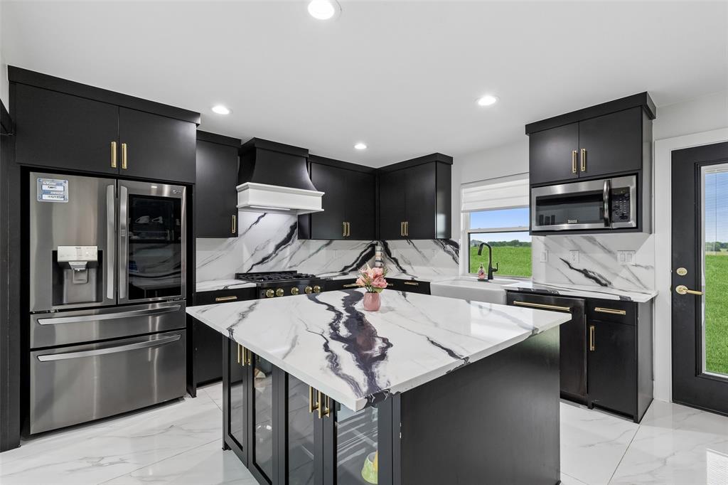 1053 Sedalia Road Van Alstyne, TX 75495 - Photo 10 of 40 a kitchen with kitchen island a sink stainless steel appliances and cabinets