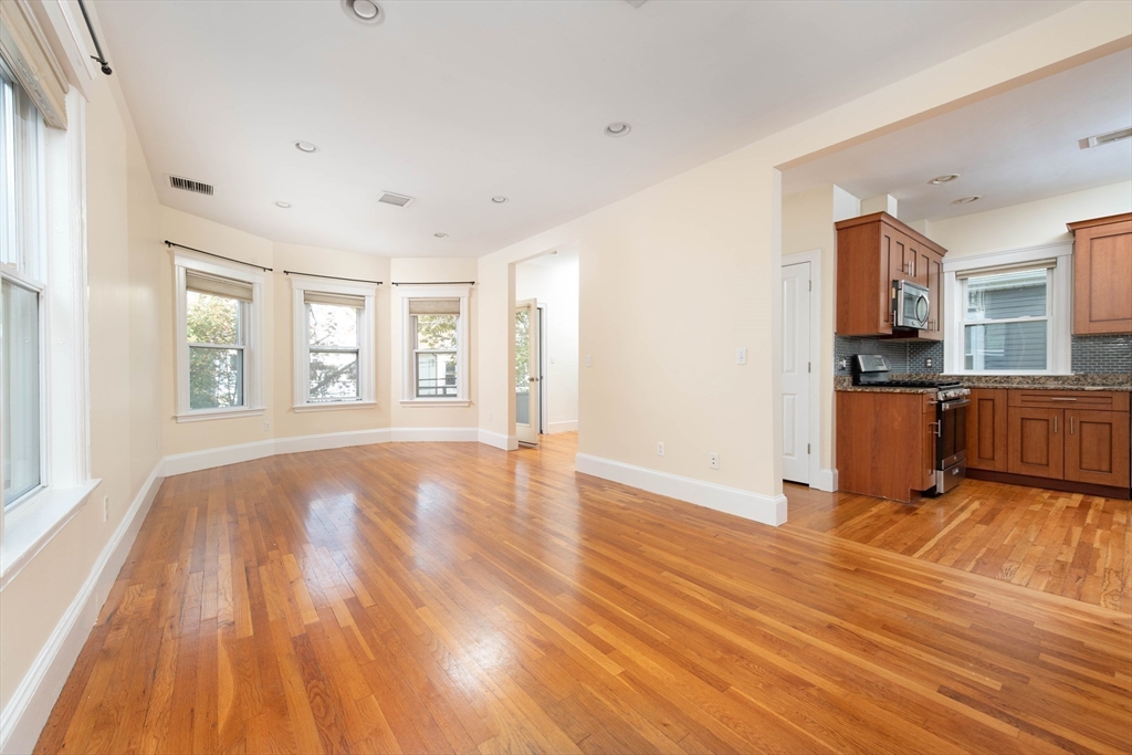 148 Albion Street, Unit 2 Somerville, MA 02144 - Photo 3 of 21 a view of an empty room with window and wooden floor