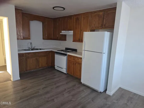 a kitchen with wooden cabinets and white appliances