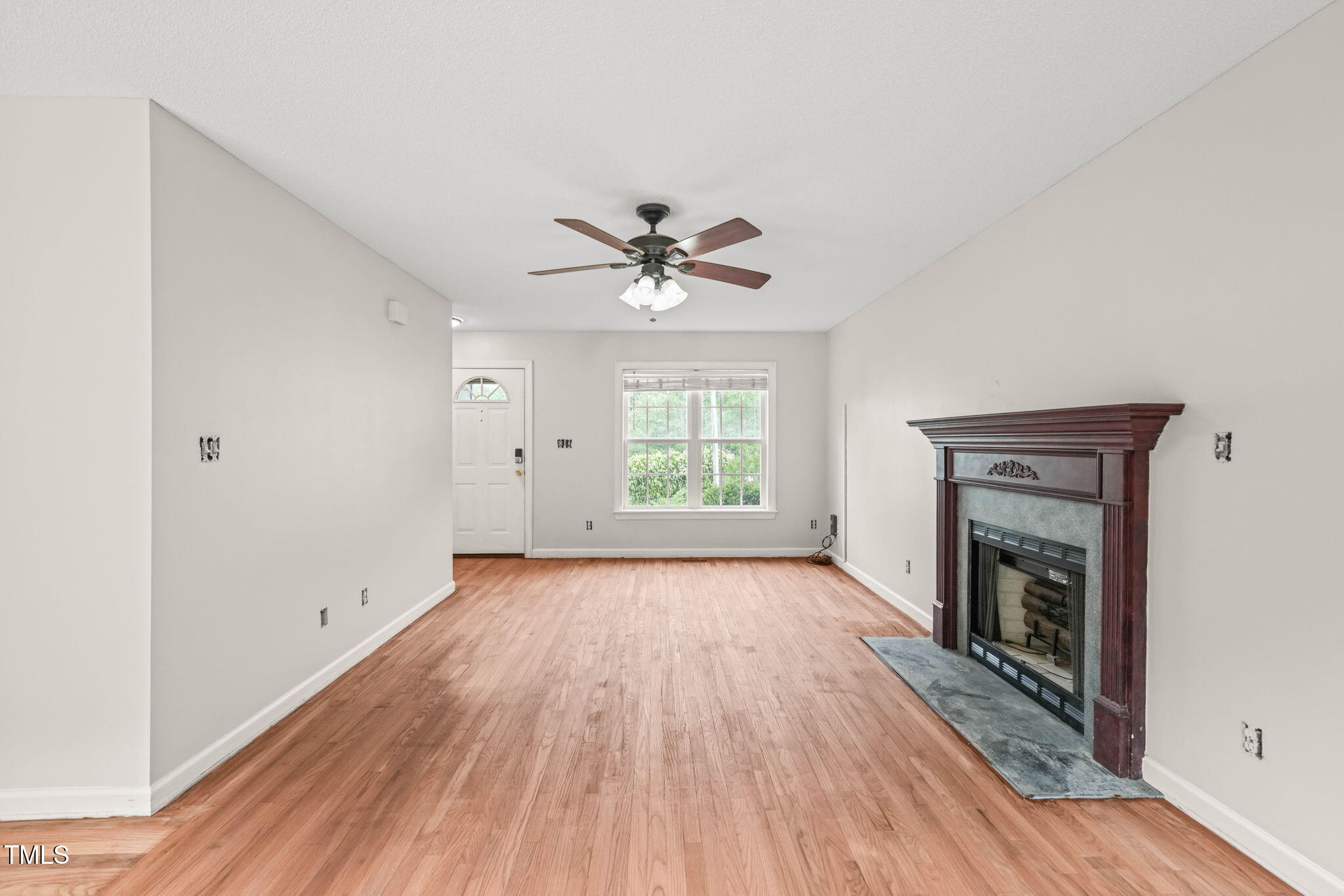 900 Borage Drive Wake Forest, NC 27587 - Photo 7 of 43 an empty room with wooden floor fireplace and windows