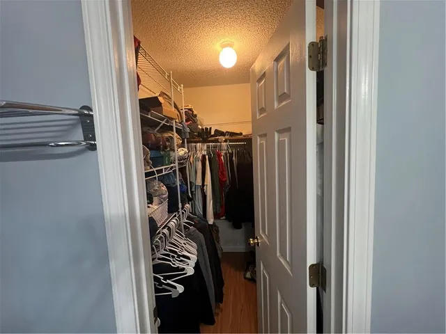 a view of walk in closet with clothes