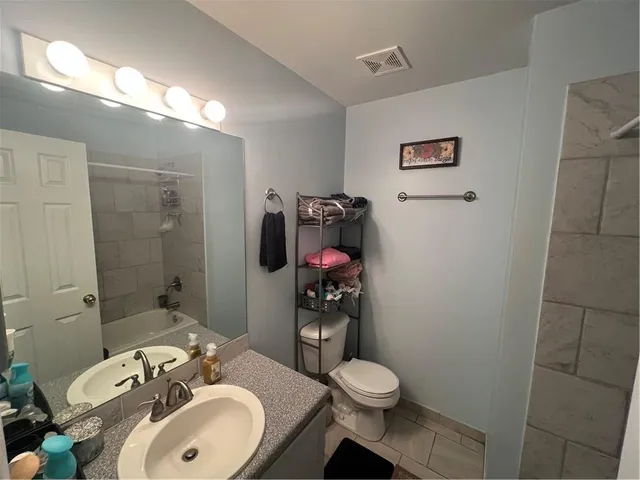 a bathroom with a sink mirror vanity and toilet