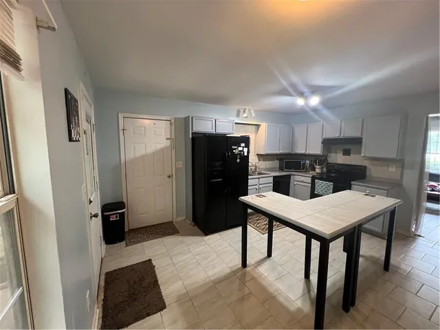 a kitchen with stainless steel appliances kitchen island granite countertop a refrigerator and a stove top oven