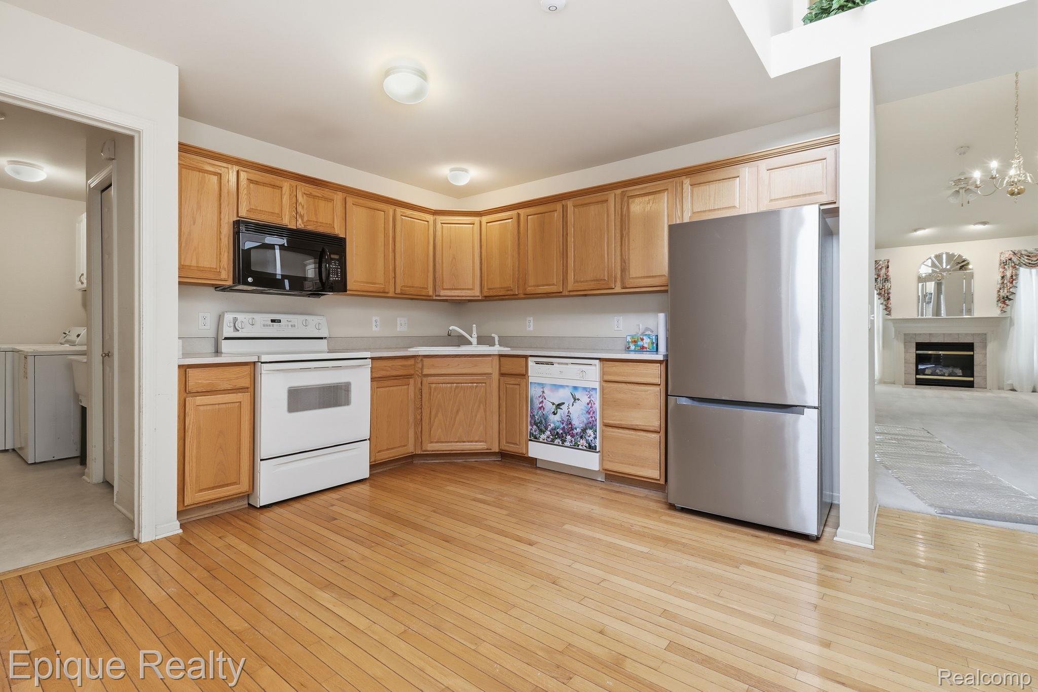 321 Cherry Grove Road Canton, MI 48188 - Photo 19 of 22 Kitchen featuring white appliances, light countertops, light wood finished floors, and a fireplace