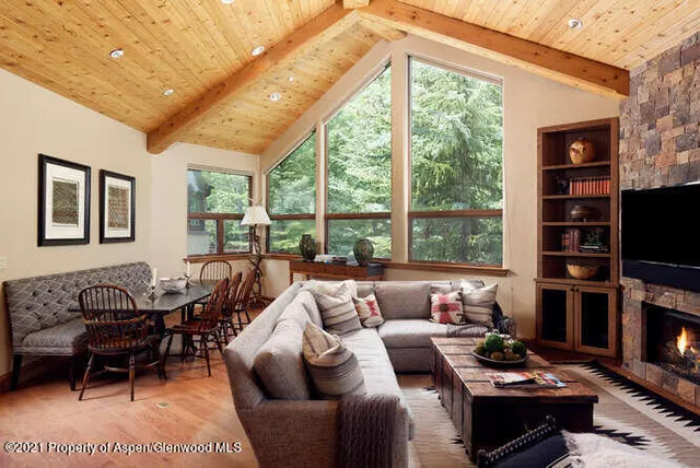 a living room with furniture a rug a fireplace and a large window