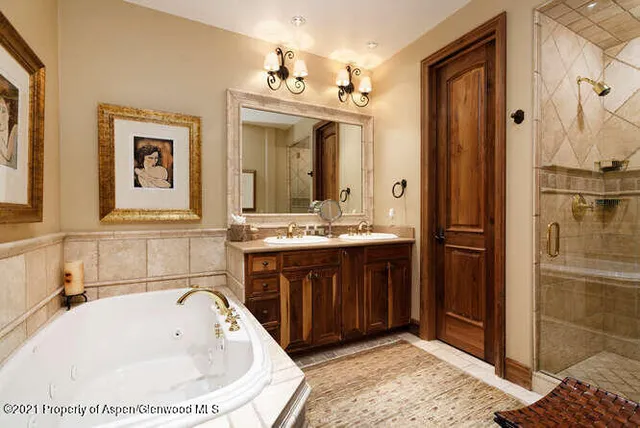 a bathroom with a tub sink and mirror