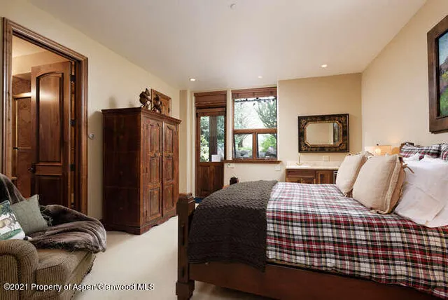 a bedroom with a bed and a dresser with mirror