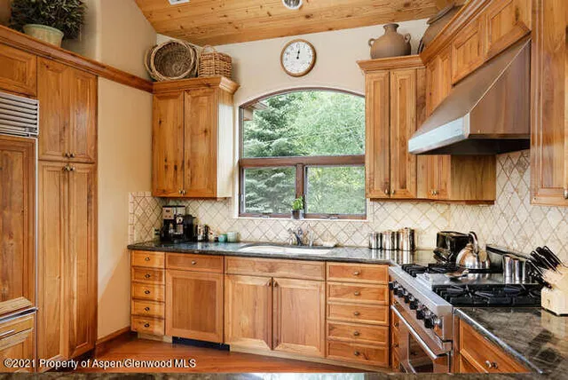 a kitchen with stainless steel appliances a stove a sink and a cabinets