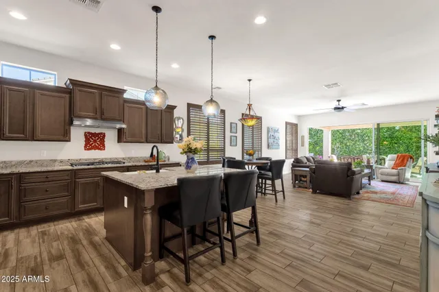 a living room with furniture floor to ceiling window hardwood floor and a flat screen tv