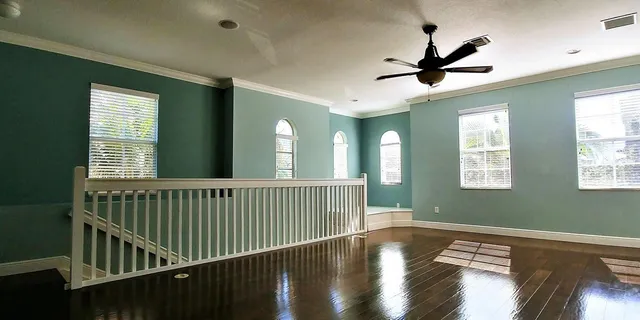 a view of a hallway with wooden floor and windows