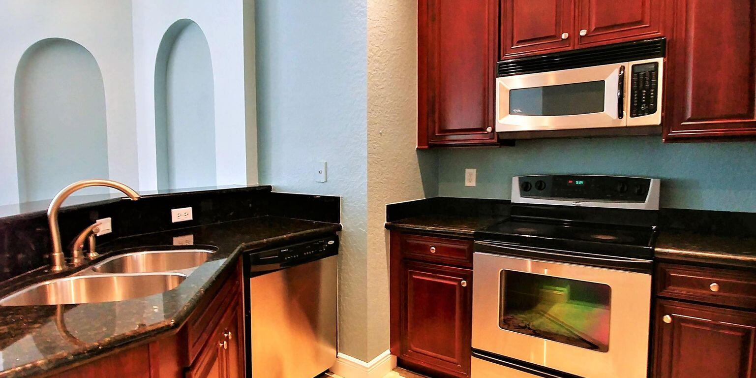 127 Seagrape Drive, Unit 201 Jupiter, FL 33458 - Photo 7 of 17 a kitchen with granite countertop a stove and a microwave