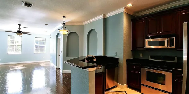 a kitchen with stainless steel appliances granite countertop a stove a sink and a microwave