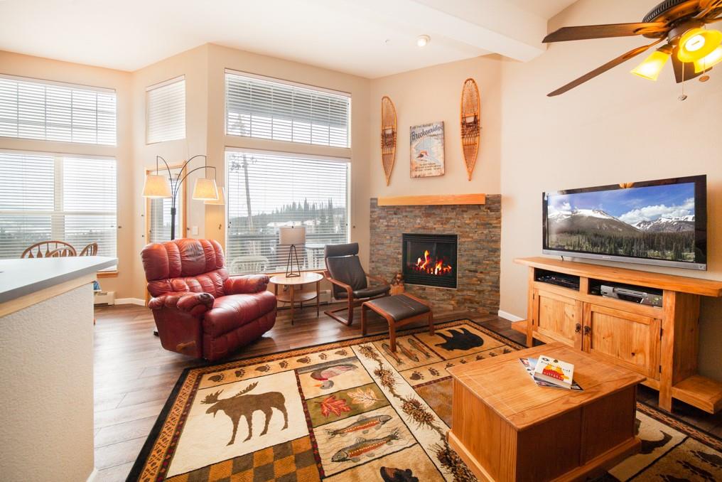 91199 Ryan Gulch Road, Unit A5 Silverthorne, CO 80498 - Photo 1 of 31 a living room with furniture a flat screen tv and a fireplace