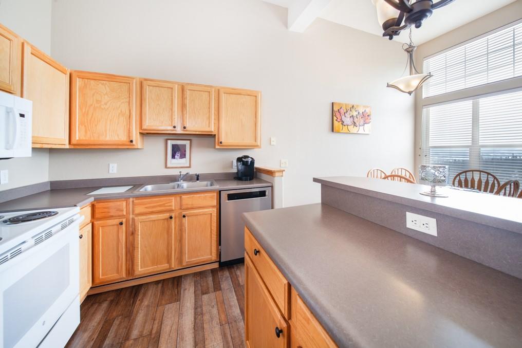 91199 Ryan Gulch Road, Unit A5 Silverthorne, CO 80498 - Photo 8 of 31 a kitchen with stainless steel appliances granite countertop a sink dishwasher stove and wooden cabinets