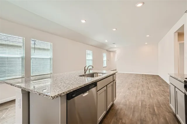 a kitchen with granite countertop a sink and a wooden floor
