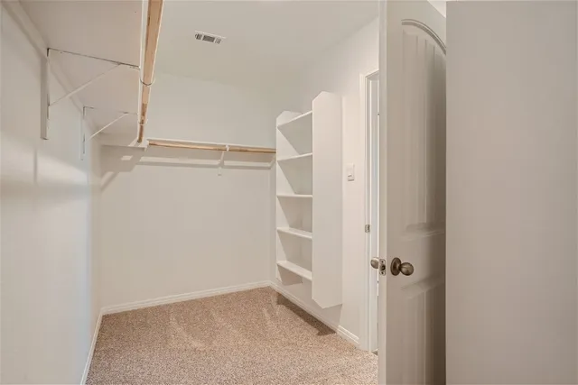 a view of walk in closet with empty racks