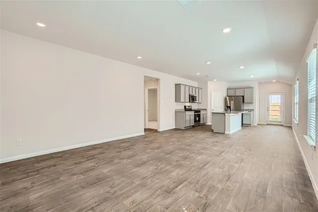 a view of a kitchen with wooden floor and a window
