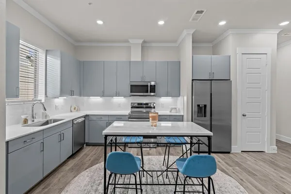 a kitchen with a refrigerator a stove a sink and chairs
