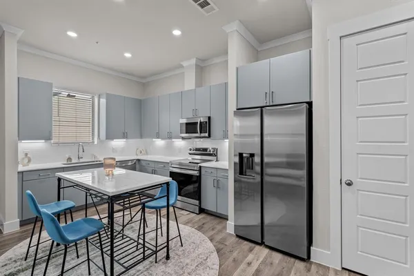 a kitchen with a refrigerator a table and chairs in it