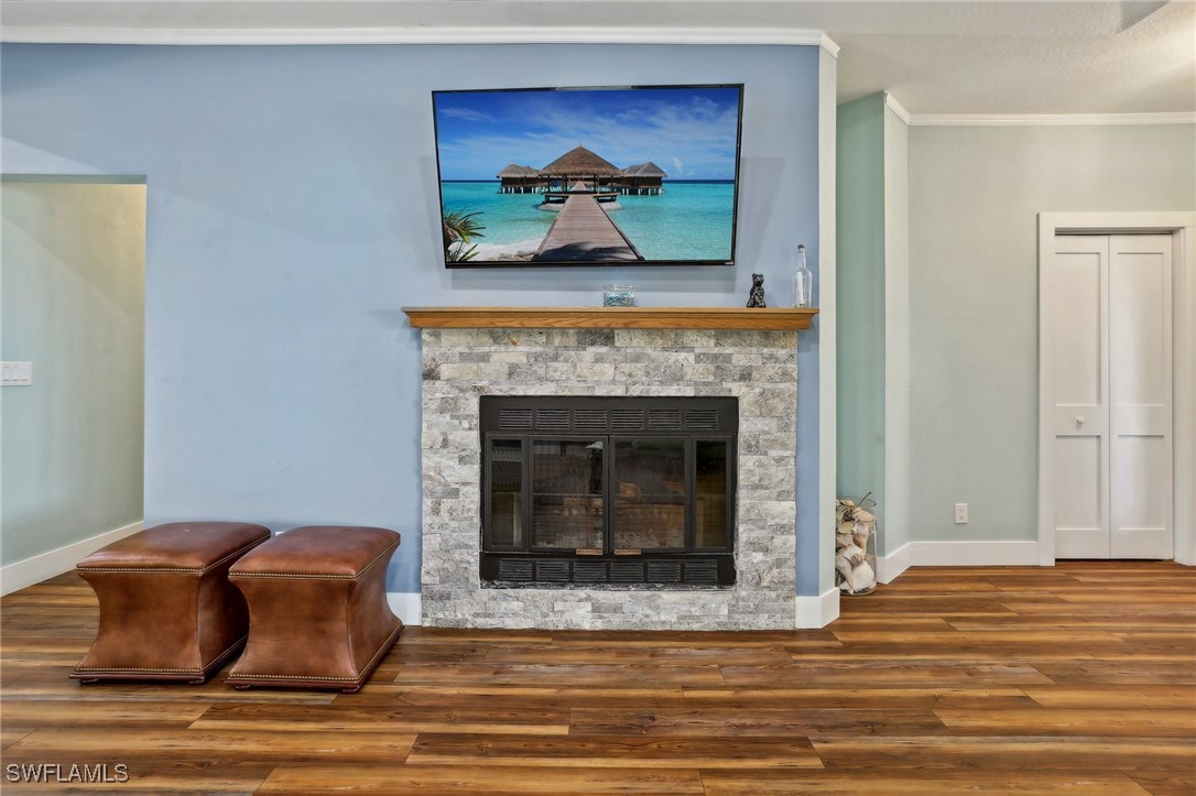 8335 Main Street Bokeelia, FL 33922 - Photo 18 of 47 a living room with a fireplace and wooden floor