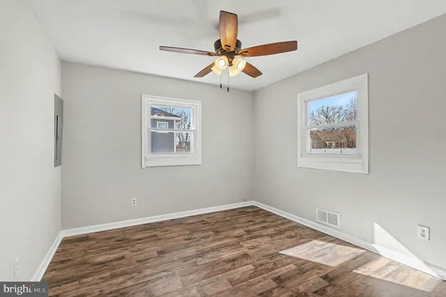 a view of a room with wooden floor and ceiling fan