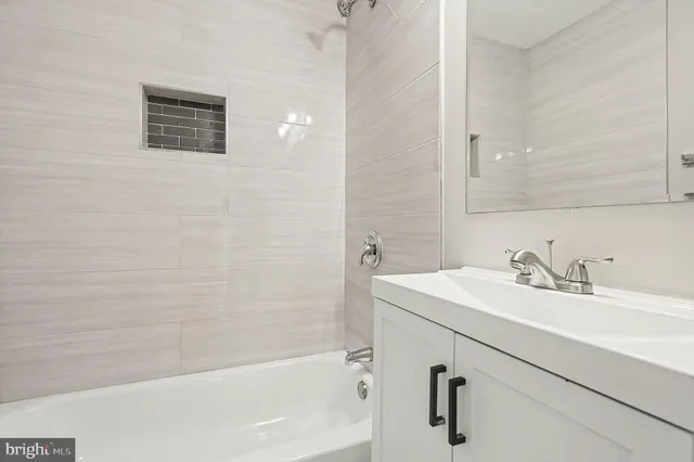 a bathroom with a sink a vanity and a bathtub