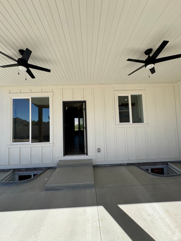389 West 2100 South Perry, UT 84302 - Photo 11 of 21 Covered patio featuring two ceiling fans, white board-and-batten siding, and concrete flooring