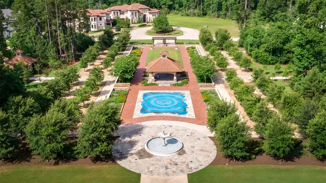an aerial view of residential houses with outdoor space and trees