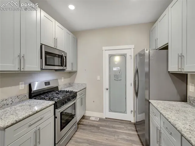 a kitchen with stainless steel appliances granite countertop a stove a refrigerator and a microwave
