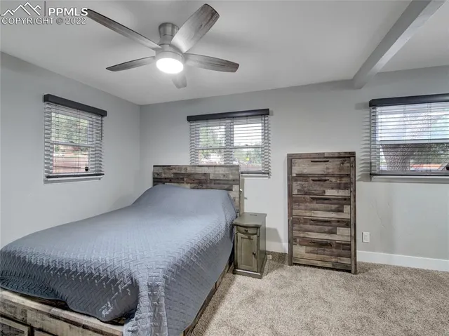 a view of empty room with a fireplace and chandelier fan