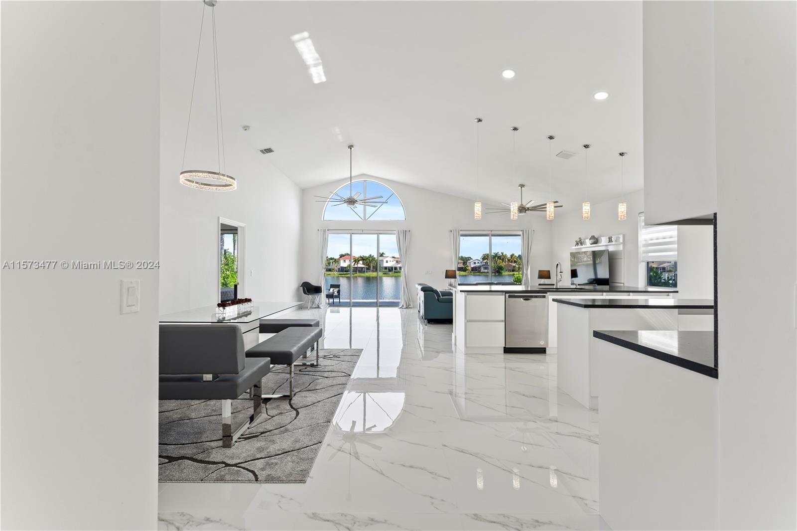 a kitchen with stainless steel appliances kitchen island granite countertop a refrigerator and a view of living room