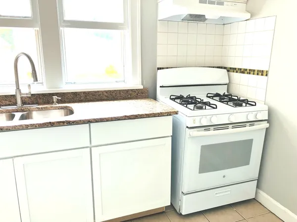 a white stove top oven sitting inside of a kitchen