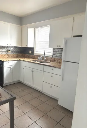 a kitchen with a sink cabinets and a refrigerator