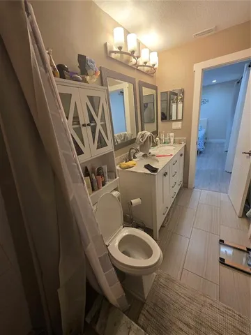 a bathroom with a toilet a sink and mirror
