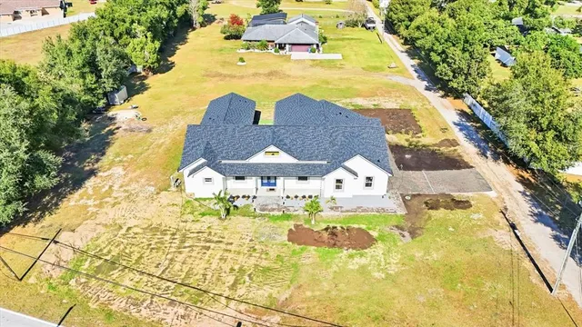 a view of a swimming pool with lawn chairs and plants