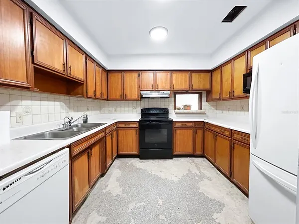 a kitchen with granite countertop a sink window and cabinets