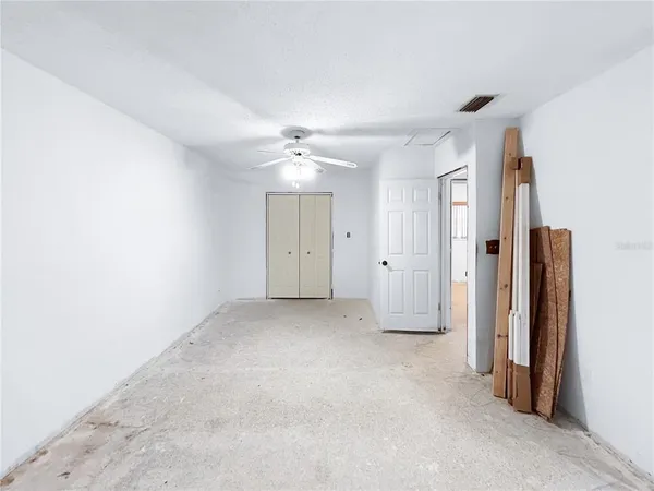 a view of a room with a ceiling fan and a window