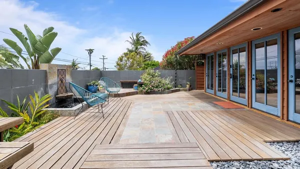 a view of backyard with outdoor seating and plants