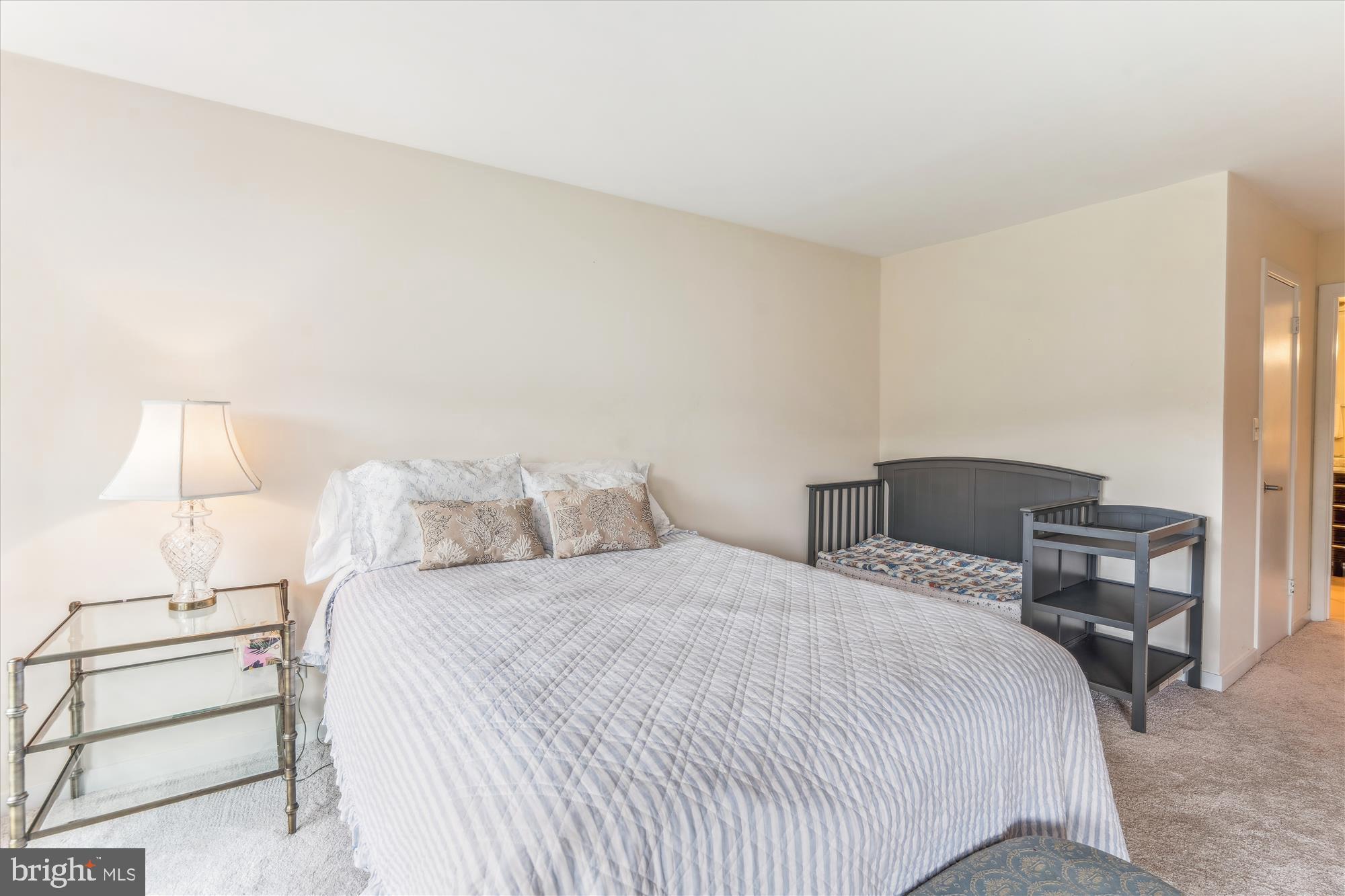 2108 Chesapeake Harbour Drive East, Unit 201 Annapolis, MD 21403 - Photo 25 of 82 a bedroom with a bed and a lamp on table