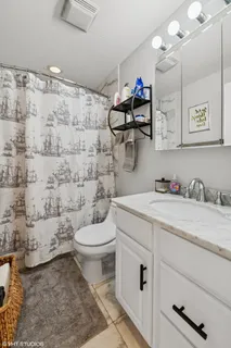 a bathroom with a granite countertop toilet sink and mirror