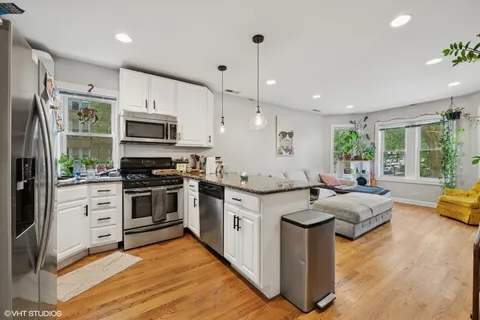 a kitchen with stainless steel appliances granite countertop a stove refrigerator and microwave