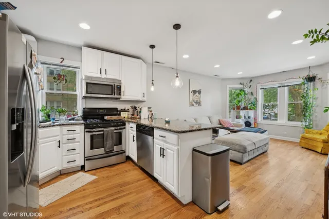 a kitchen with stainless steel appliances granite countertop a stove refrigerator and microwave