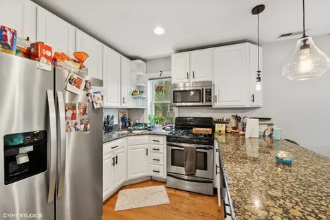 a kitchen with stainless steel appliances granite countertop a refrigerator a stove top oven a sink and dishwasher