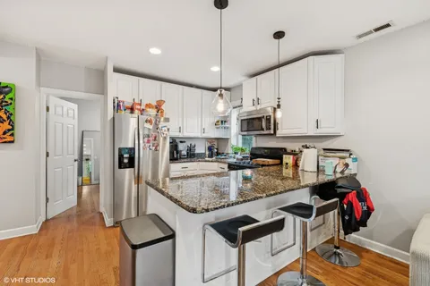 a kitchen with stainless steel appliances granite countertop a sink refrigerator and cabinets