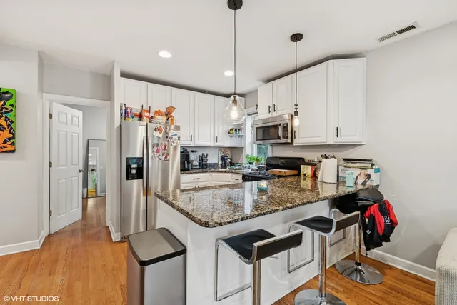 a kitchen with stainless steel appliances granite countertop a sink refrigerator and cabinets