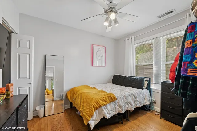 a bedroom with a bed and a flat tv screen on a dresser