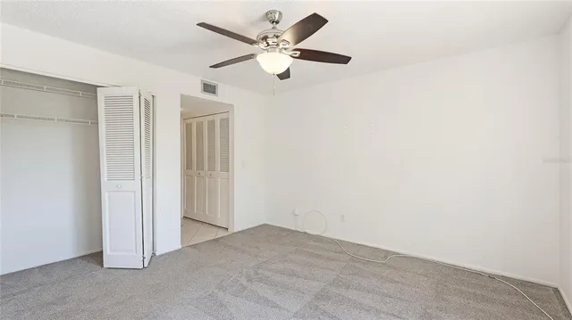 an empty room with windows and fan