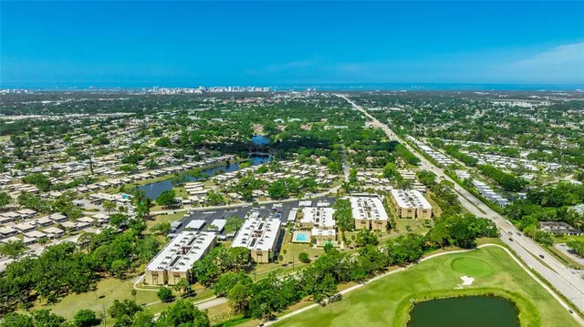 an aerial view of residential houses with outdoor space and trees